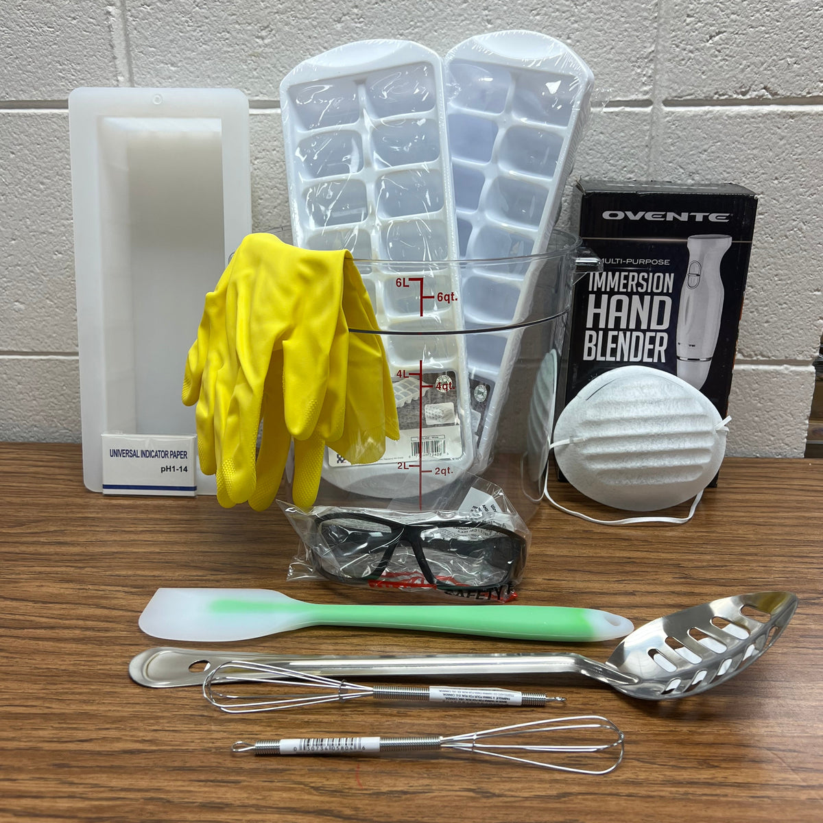 Soapmaking equipment bundle including a 6 liter bowl, 2 ice cube trays, chemical resistant gloves, 10" loaf mold, PH strips, safety goggles, a hand blender, dust mask, heat safe spatula, stainless steel spoon and 2 six inch colorant whisks.