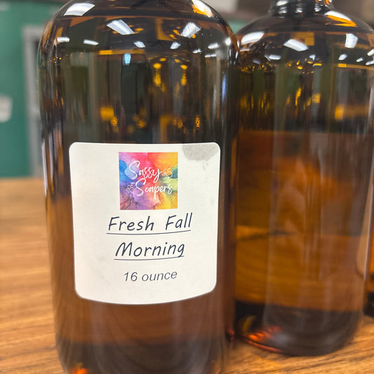 Bottle of 'Fresh Fall Morning' fragrence oils with a label on a wooden surface