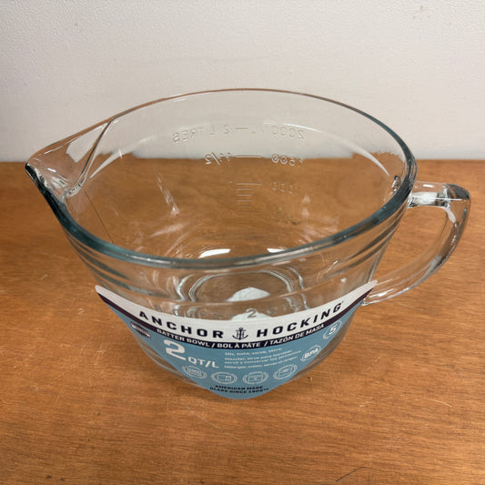 Clear glass mixing/measuring cup with handle on a wooden surface