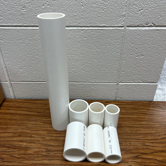 White pipes on a wooden surface with a tiled wall background