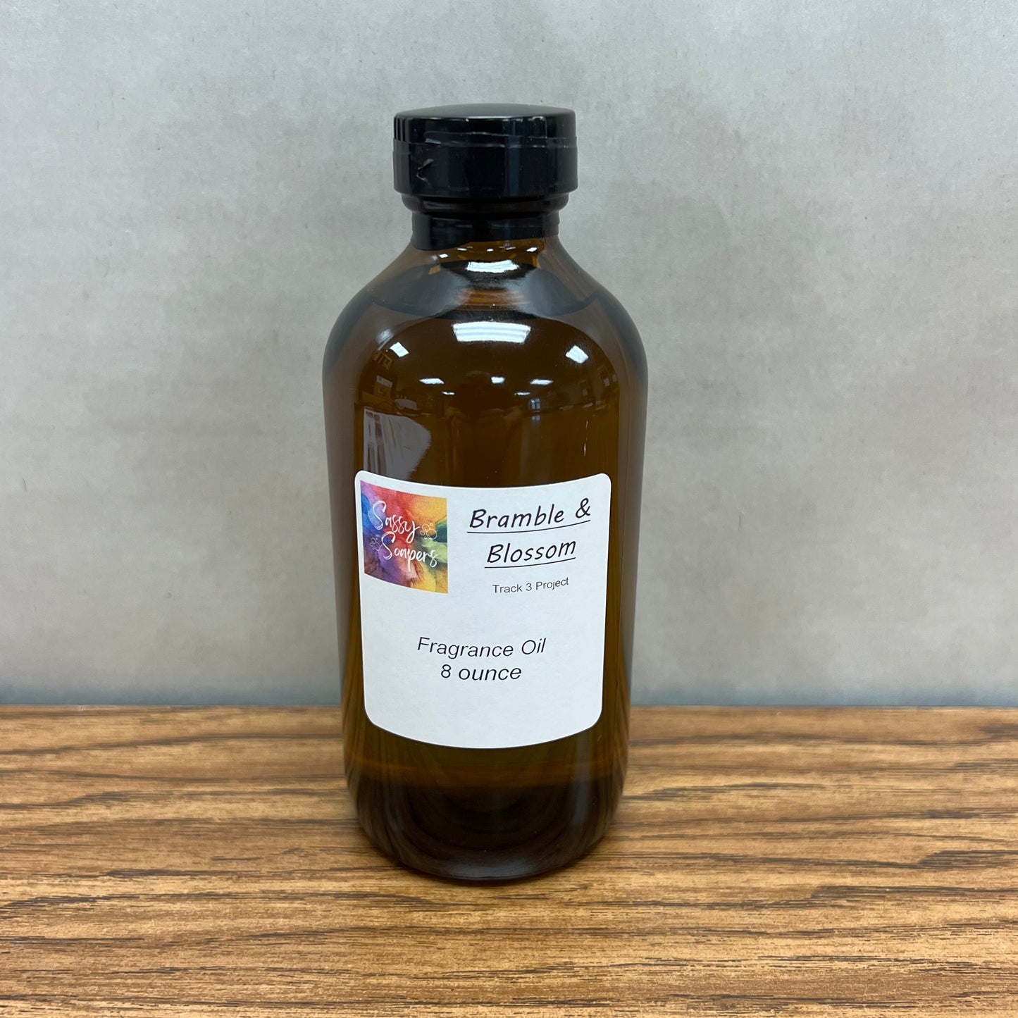 8 ounce, brown glass bottle of Bramble and Blossom fragrance oil for soap making.