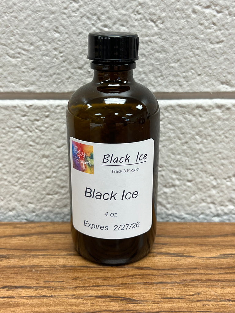 4 oz Bottle of 'Black Ice' fragrance oil on a wooden surface with a white wall background.  Expires 2/27/2026