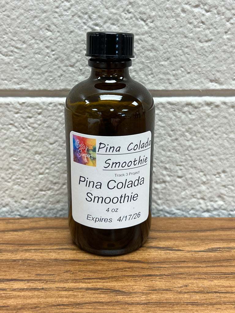 4 oz Bottle of Pina Colada Smoothie fragrance oil on a white and wooden surface.  Expires 4/17/2026