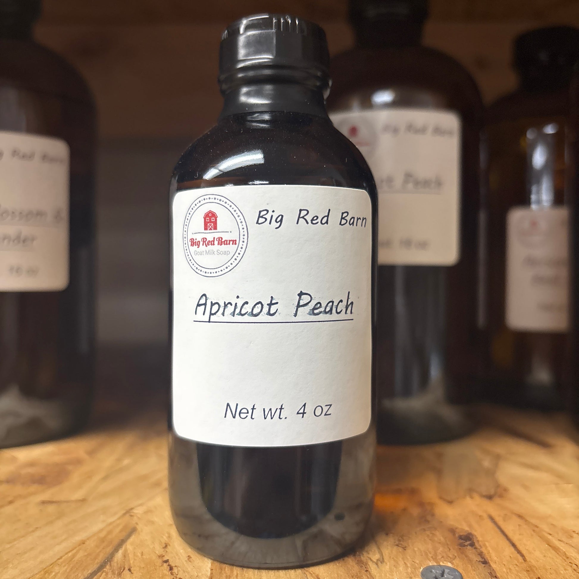 Bottle of Big Red Barn Apricot Peach fragrence oils on a wooden surface