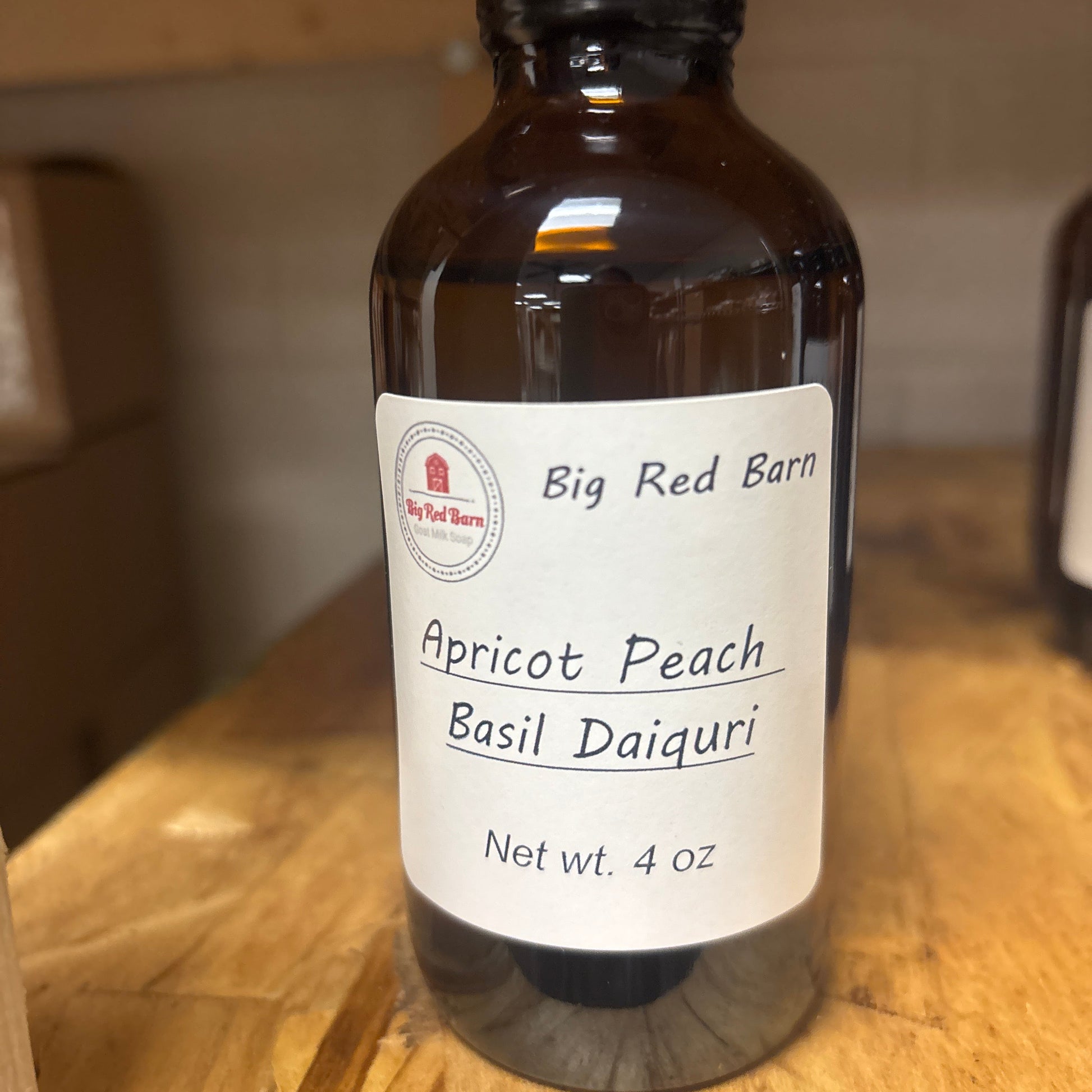 Bottle of Big Red Barn Apricot Peach Basil Daiquiri fragrence oils on a wooden surface