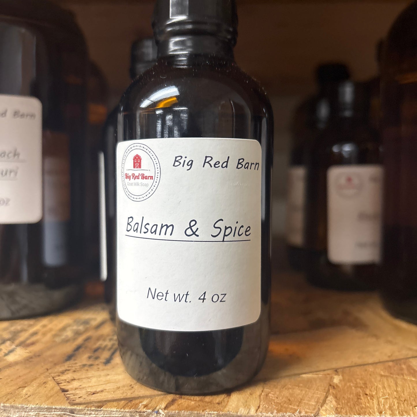 Bottle of 'Big Red Barn' Balsam & Spice fragrance on a wooden surface