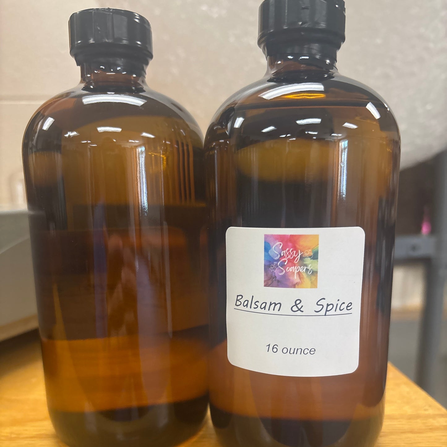 Two brown bottles with Balsam & Spice fregrence oils  label on a wooden surface