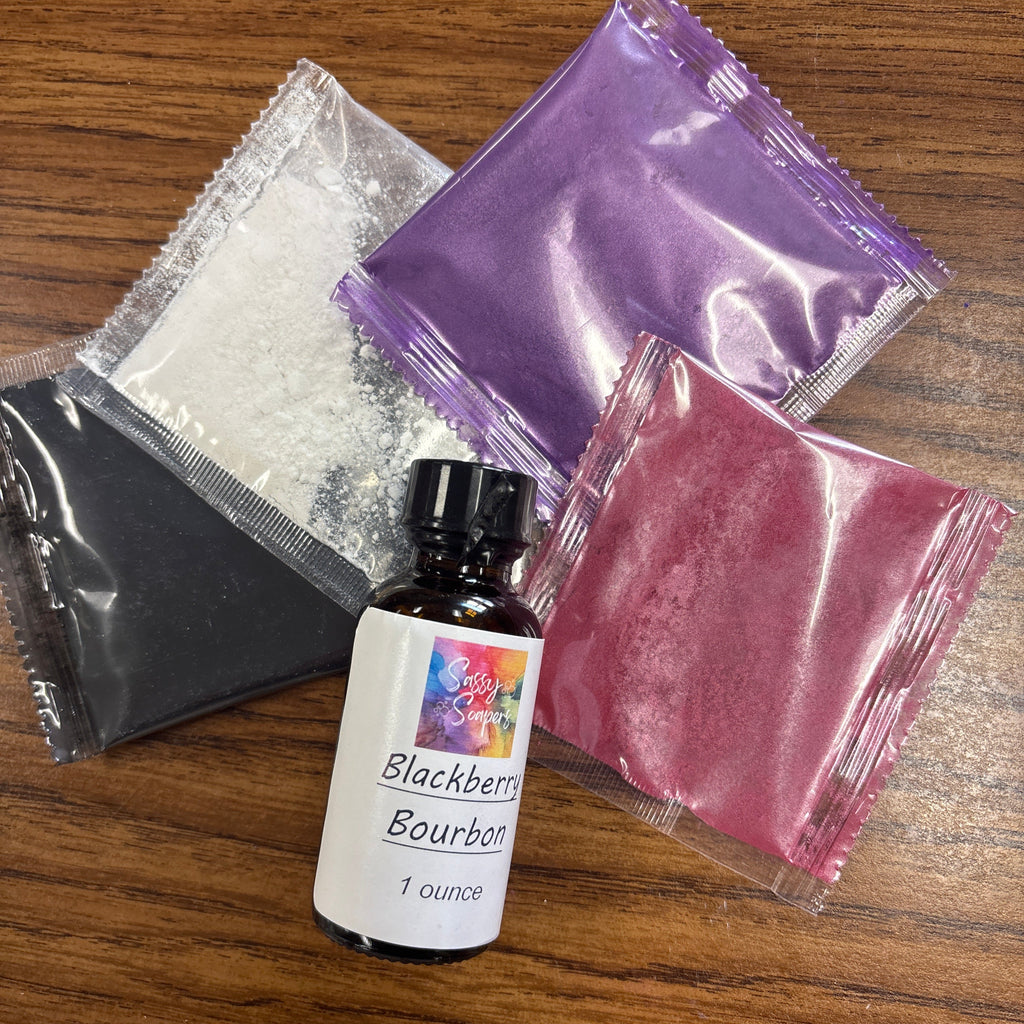 Bottle of Blackberry Breeze fragrence with purple, pink, and white powders on a wooden surface