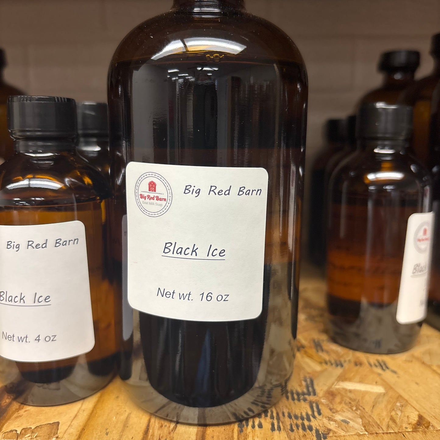 Bottles of Big Red Barn Black Ice fragrance on a wooden surface