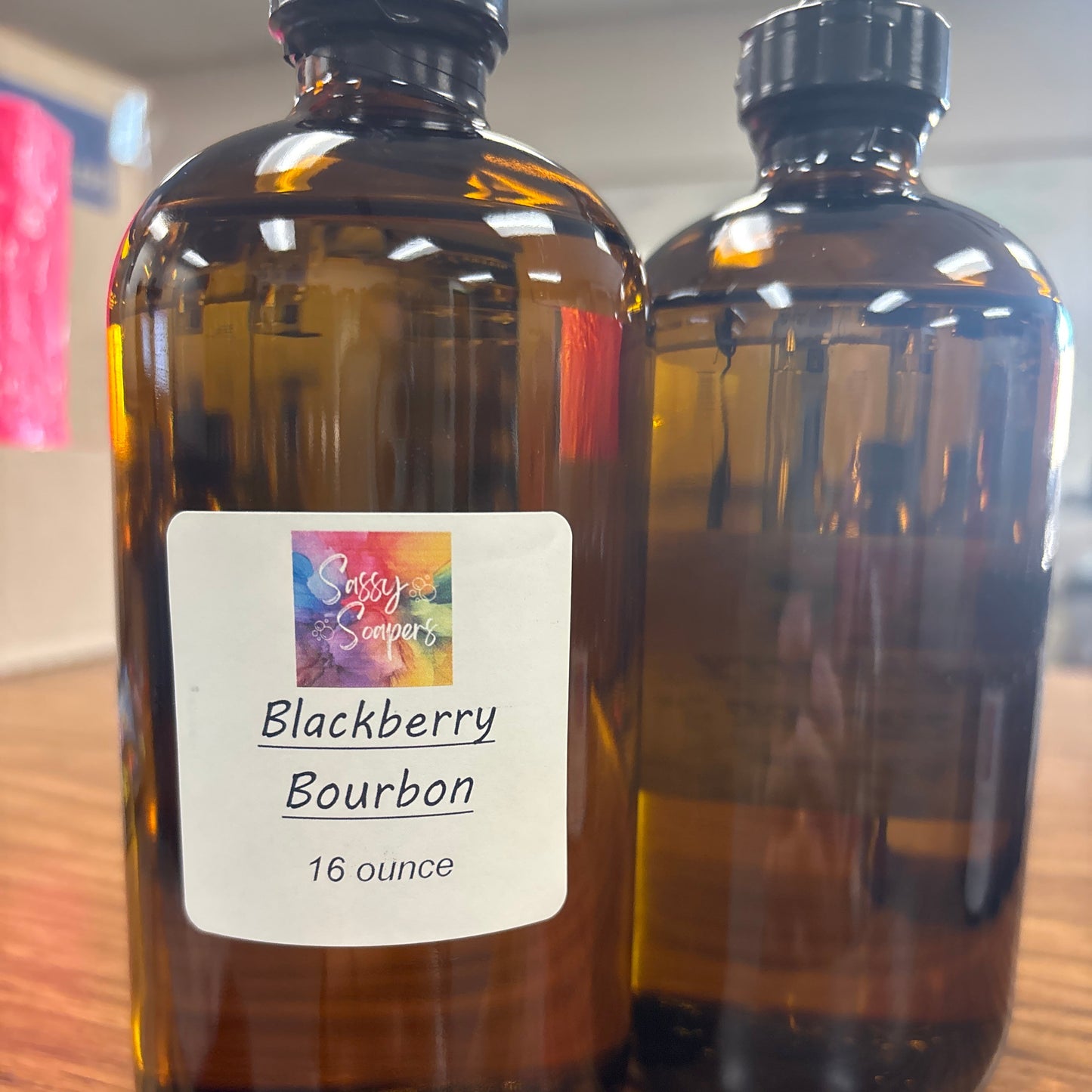 Bottle of Blackberry Bourbon fregrence oils with a colorful label on a wooden surface