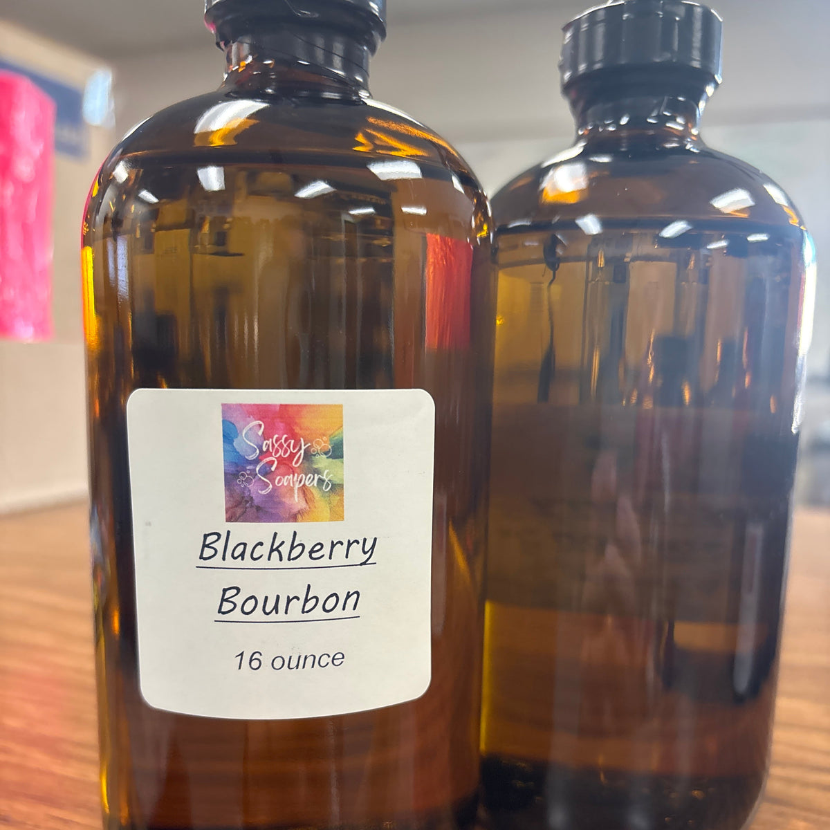 Bottle of Blackberry Bourbon fregrence oils with a colorful label on a wooden surface