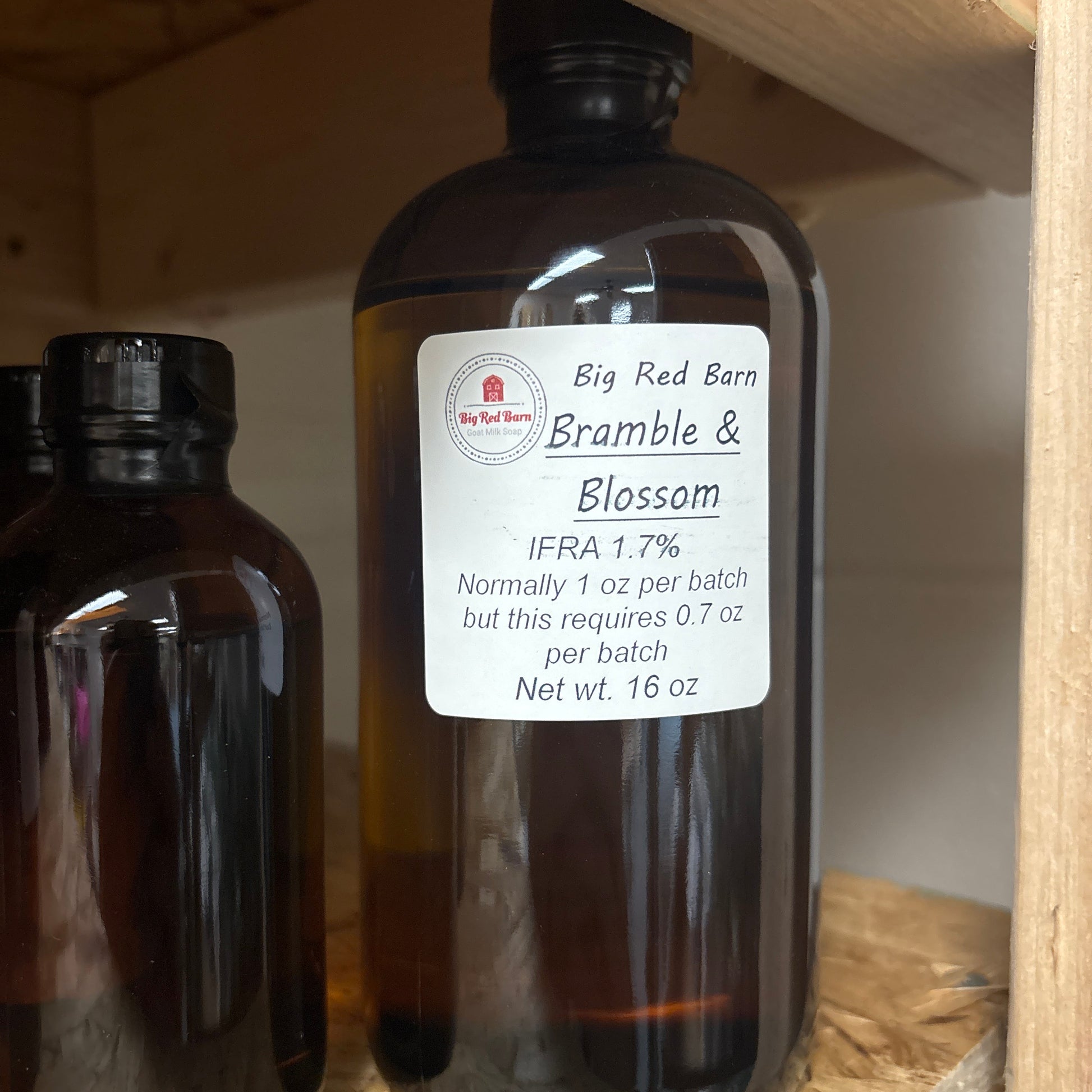 Two brown bottles with Bramble & Blossom fragrence oils labels on a wooden shelf