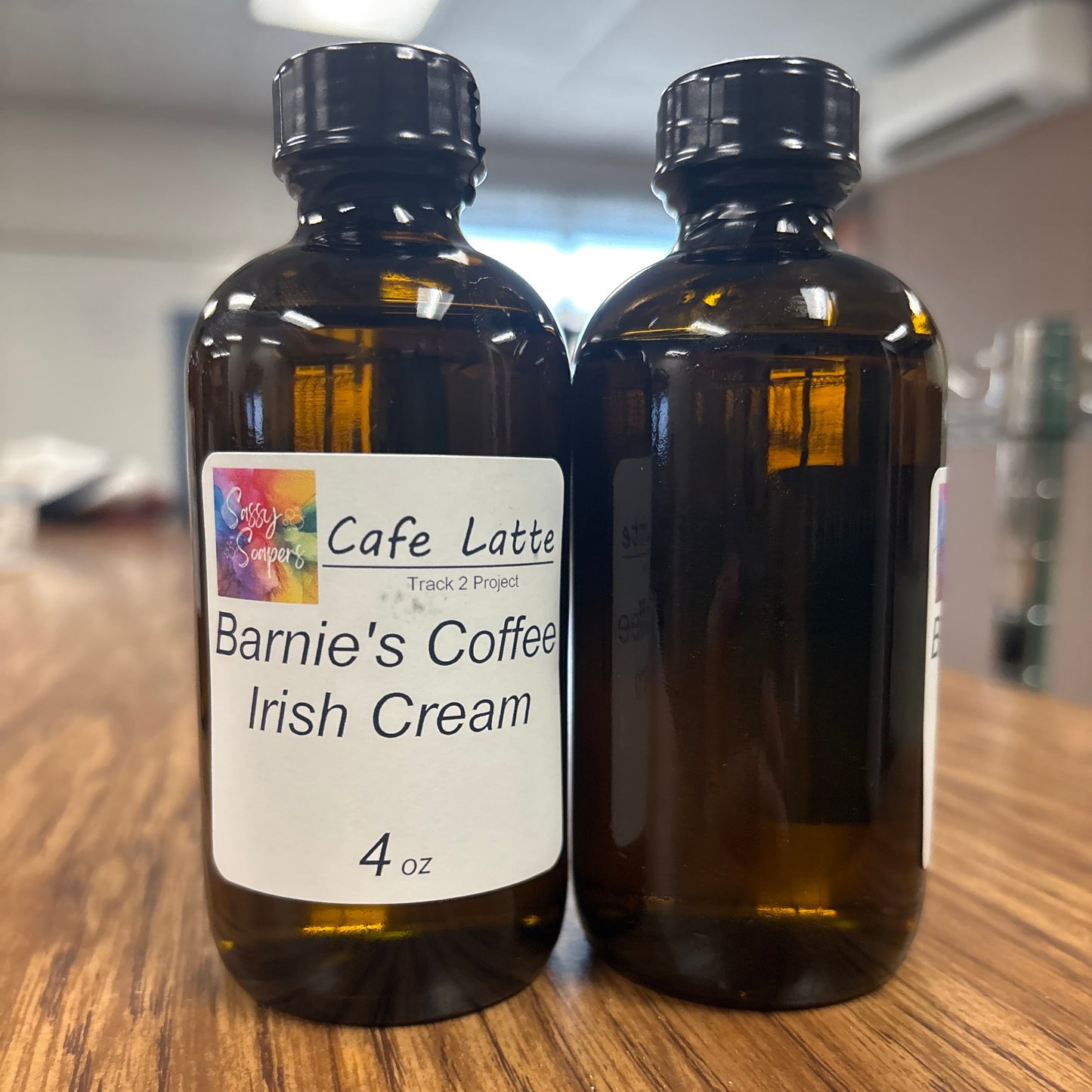 Two bottles of Barnie's Coffee Irish Cream fragrence oils on a wooden surface.