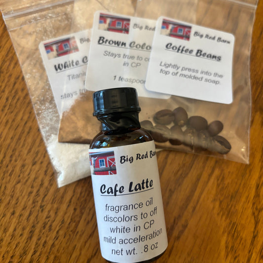 Various packaged soap project parts including different colorants and scent blends, labeled and arranged on a wooden surface.