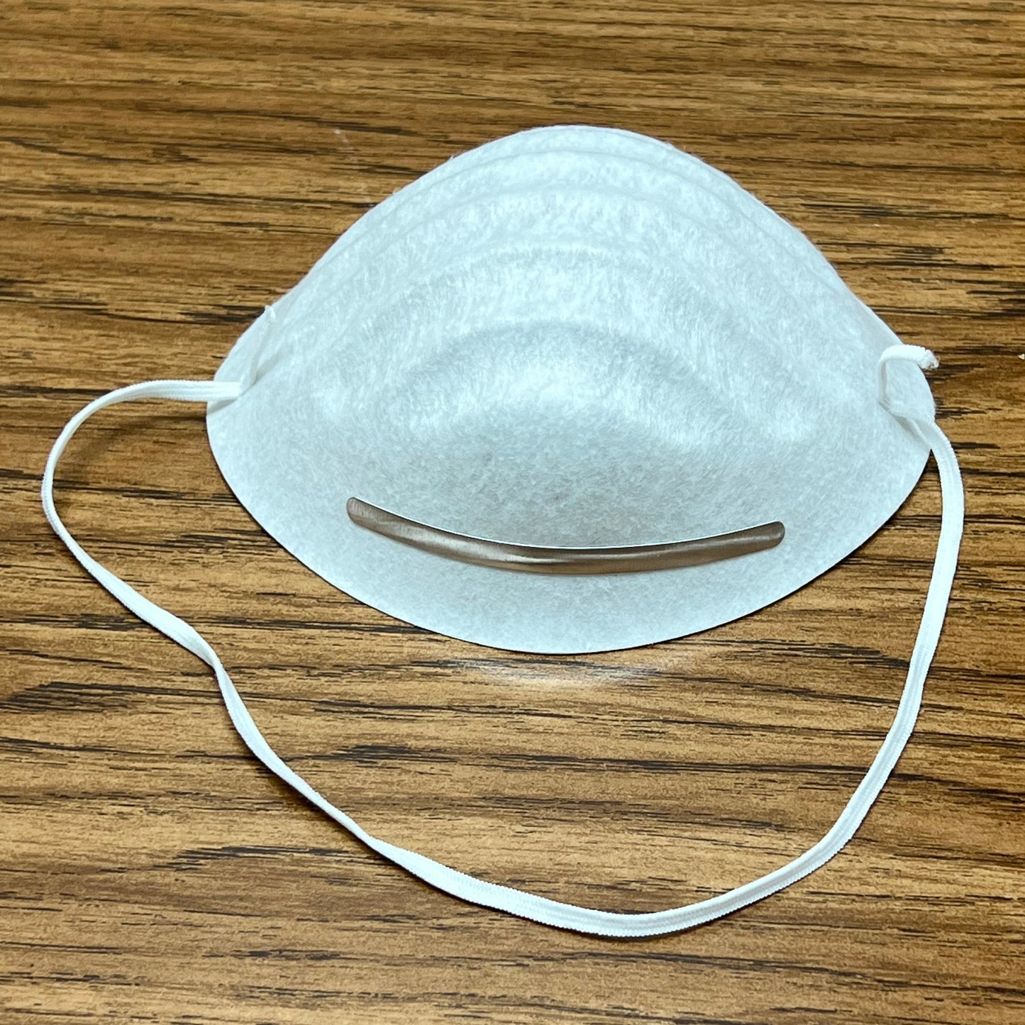 White dust mask on woodgrain table top