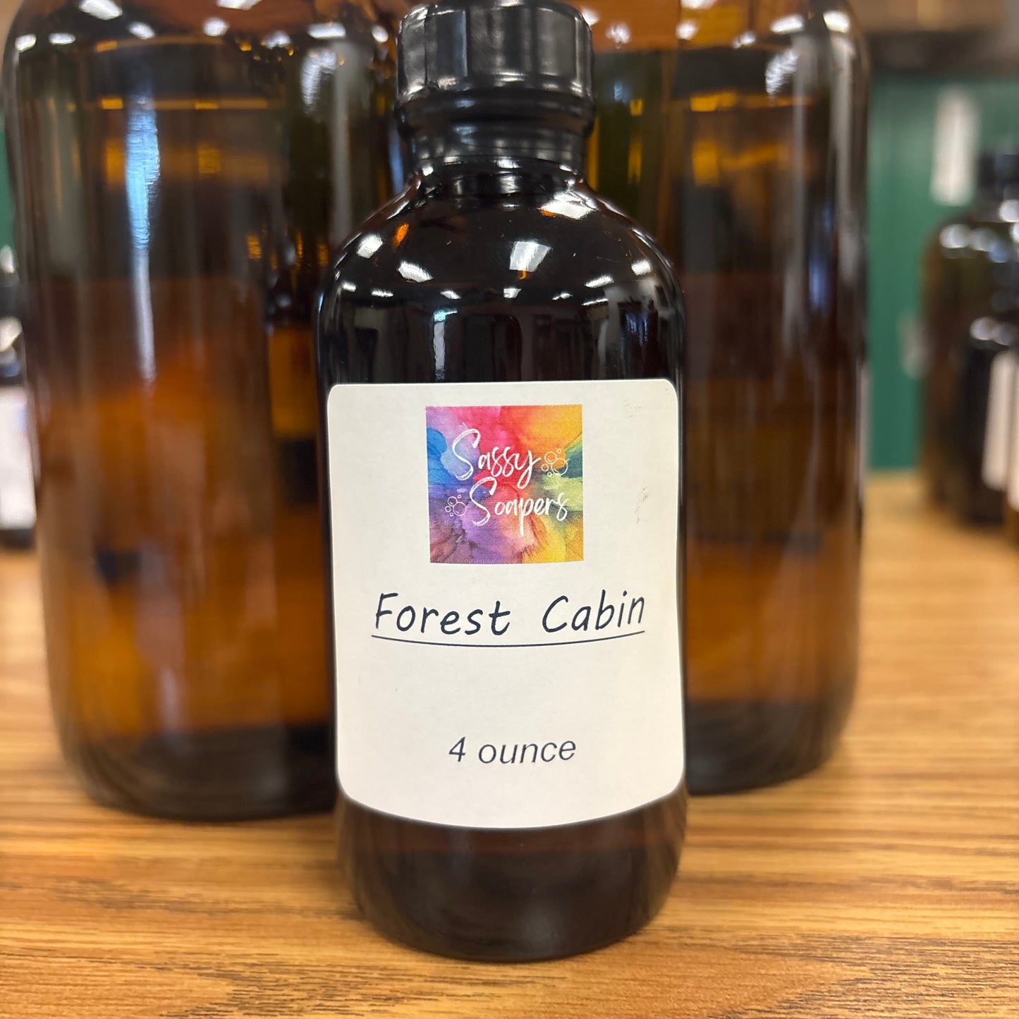 Bottle of 'Forest Cabin' fragrence oils with a label on a wooden surface