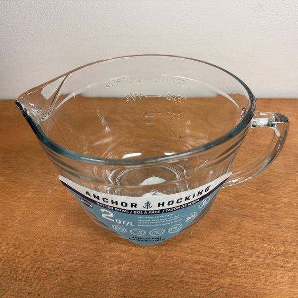 Clear glass mixing/measuring cup with handle on a wooden surface