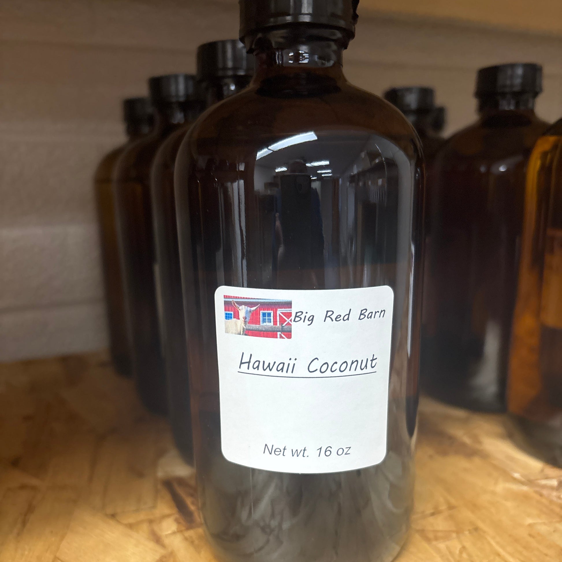A brown bottle of fragrance oil labeled Hawaii Coconut on a wooden surface