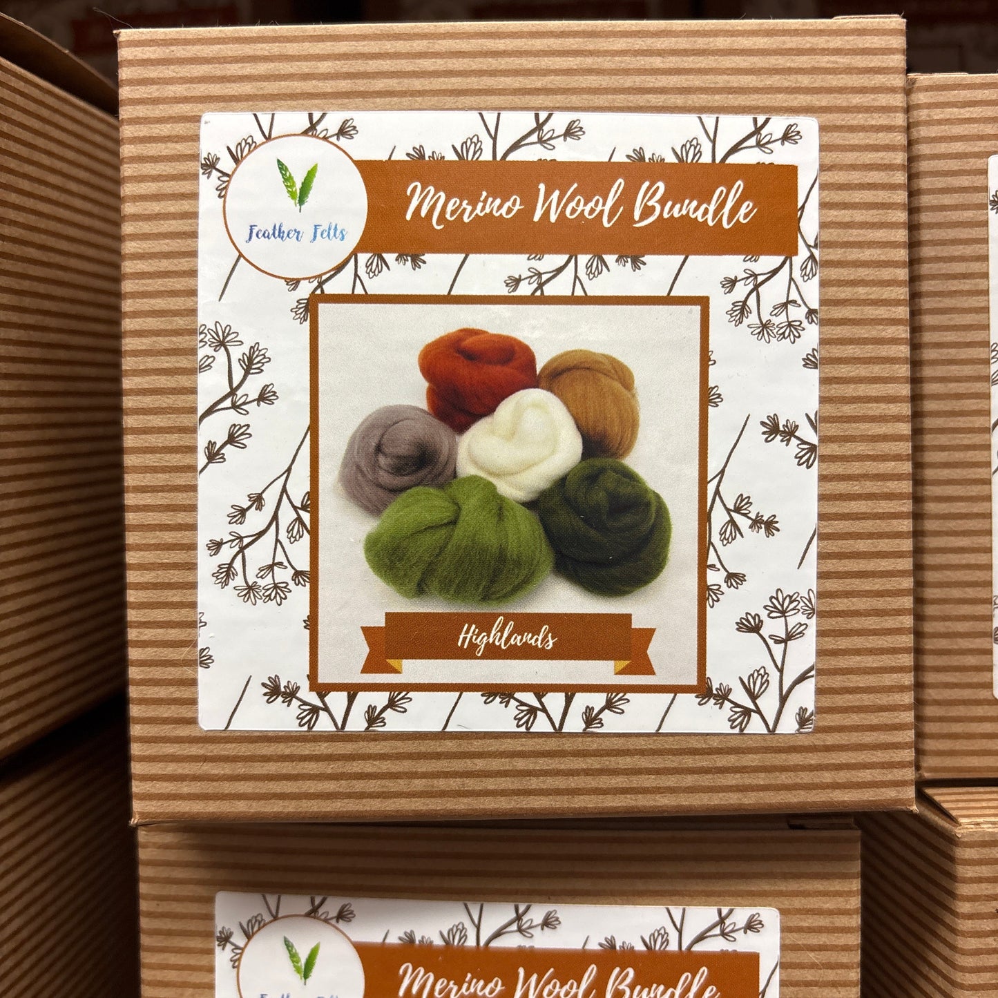 Cardboard box with a label featuring yarn balls and branding on a wooden surface.