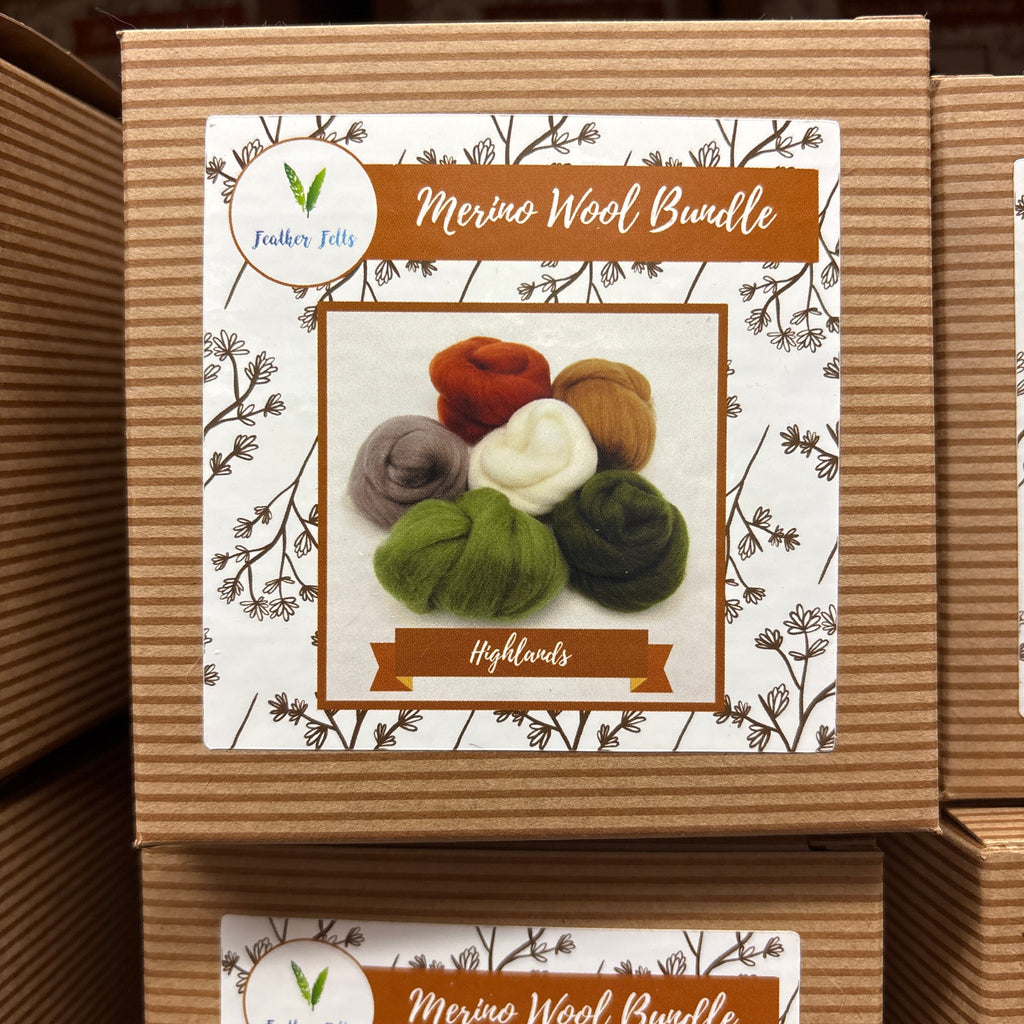 Cardboard box with a label featuring yarn balls and branding on a wooden surface.