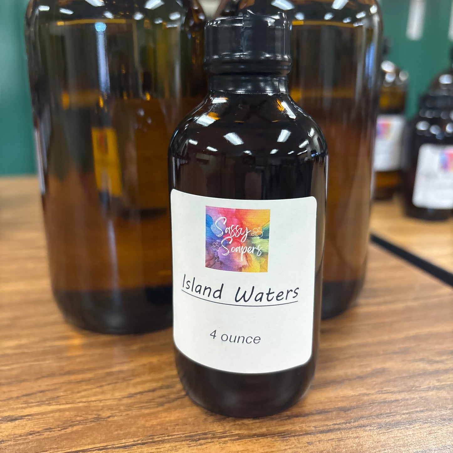 Bottle of Island Waters fragrence oils on a wooden surface with a colorful label.