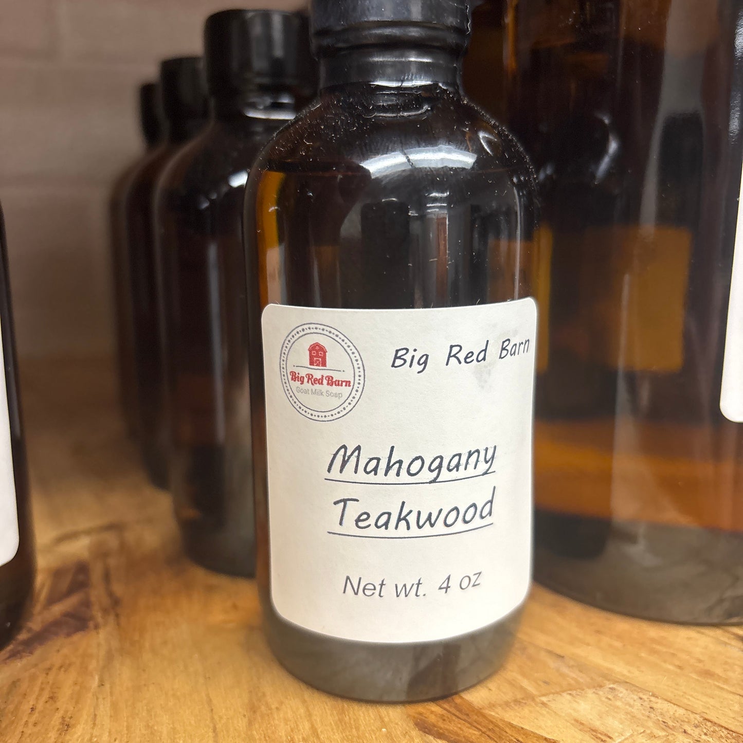 Bottle of Mahogany Teakwood fragrance on a wooden surface