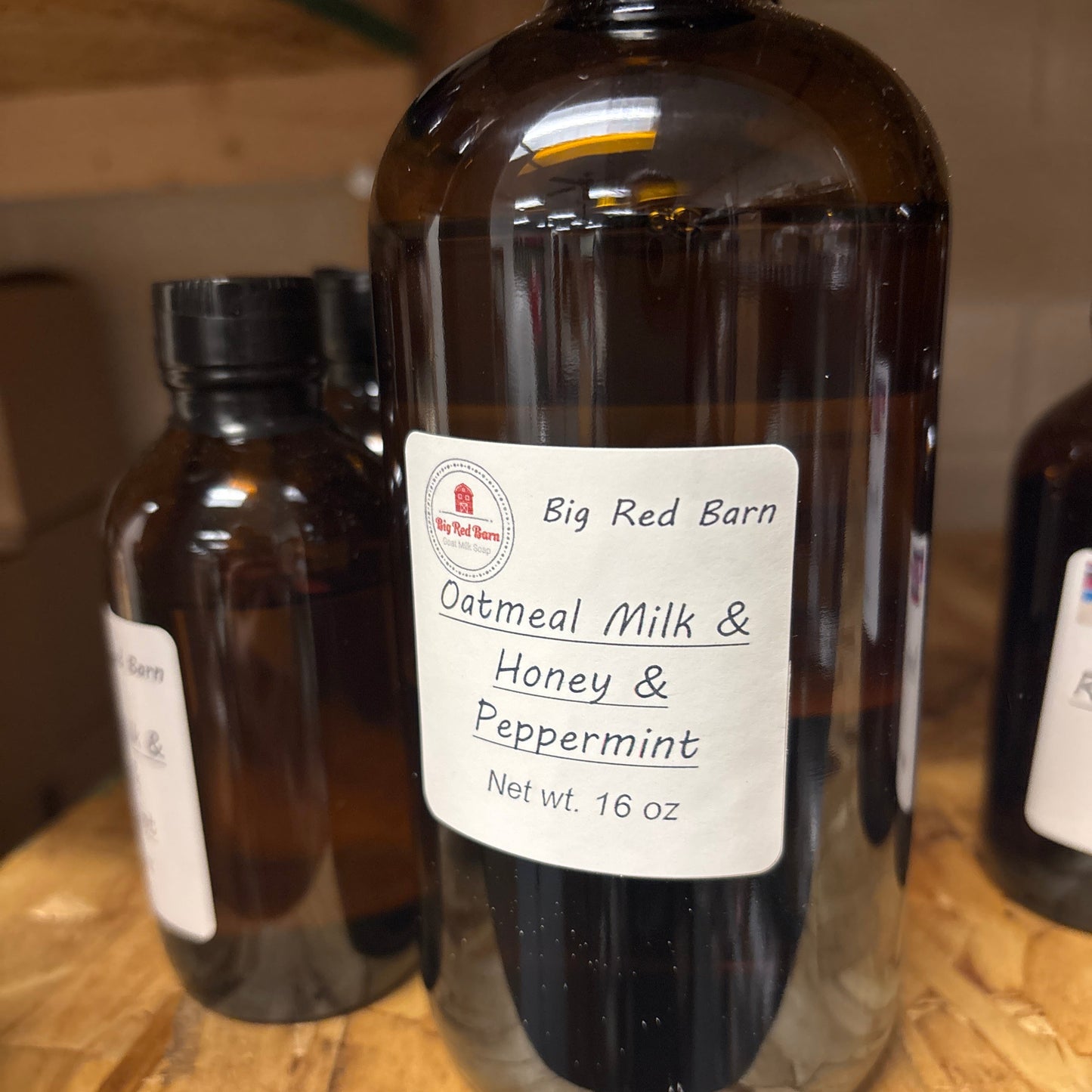 Bottle of oatmeal milk and honey peppermint fragrence oils on a wooden surface with a label visible.