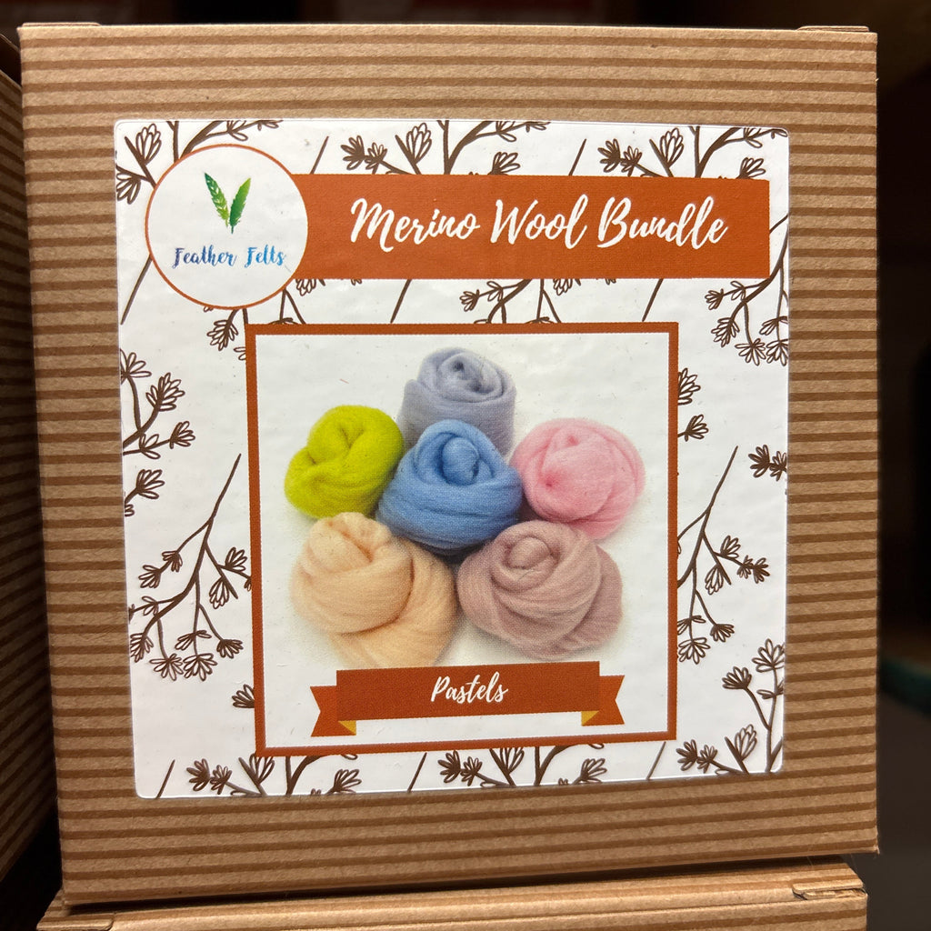 Cardboard box with a floral design and colorful wool bundles on a white background