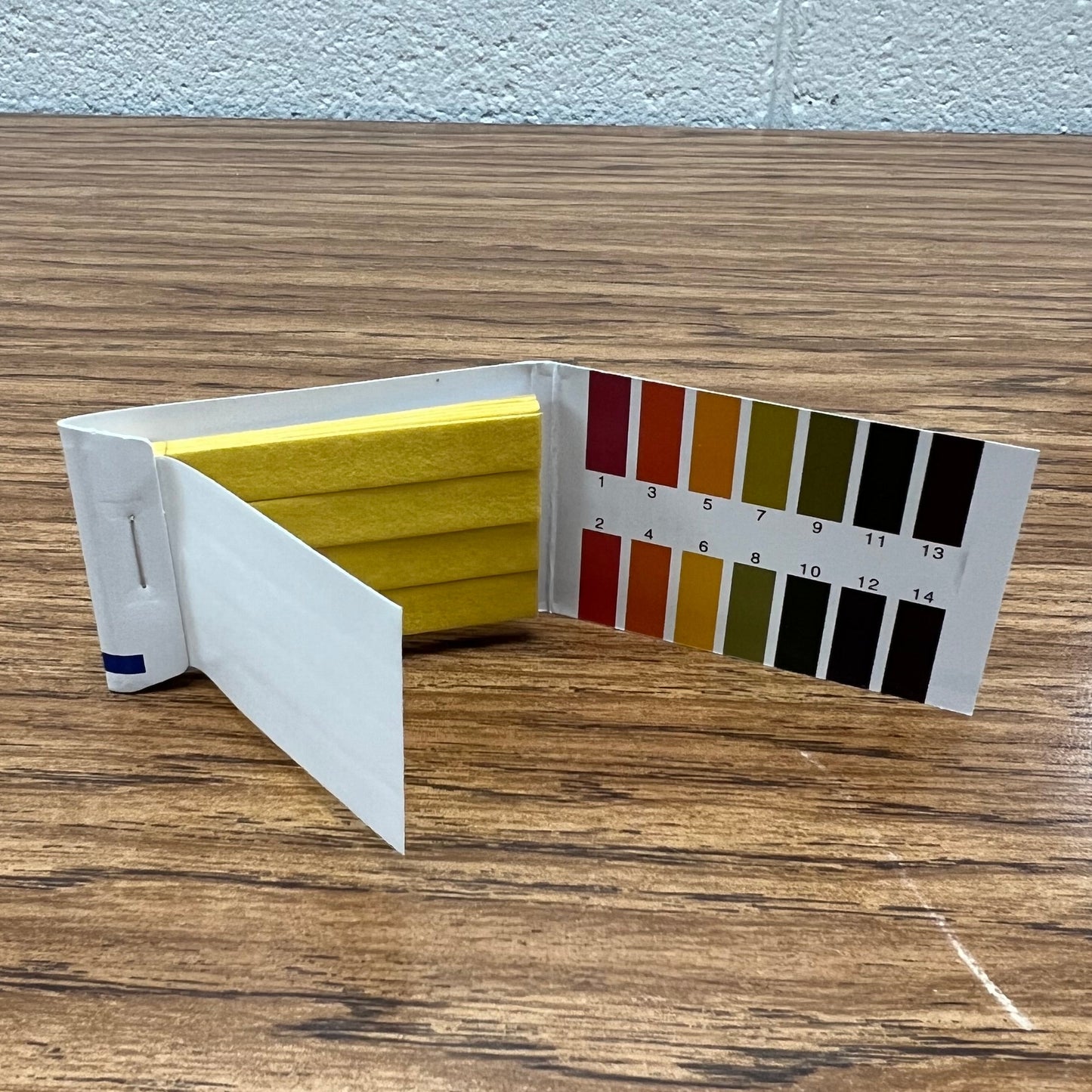 PH test strip pack opened to show color legend and strip material.