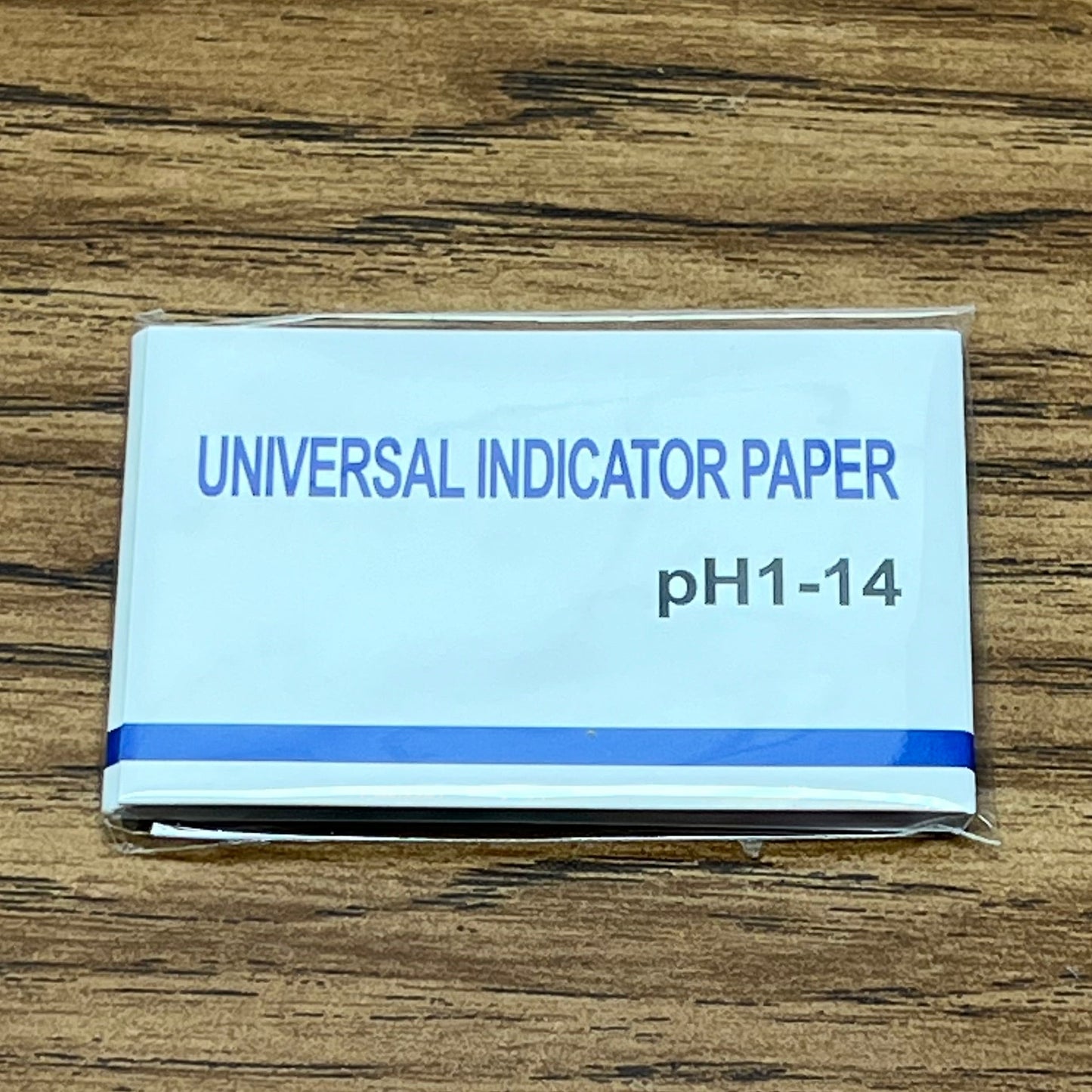 PH test strip pack on woodgrain table top