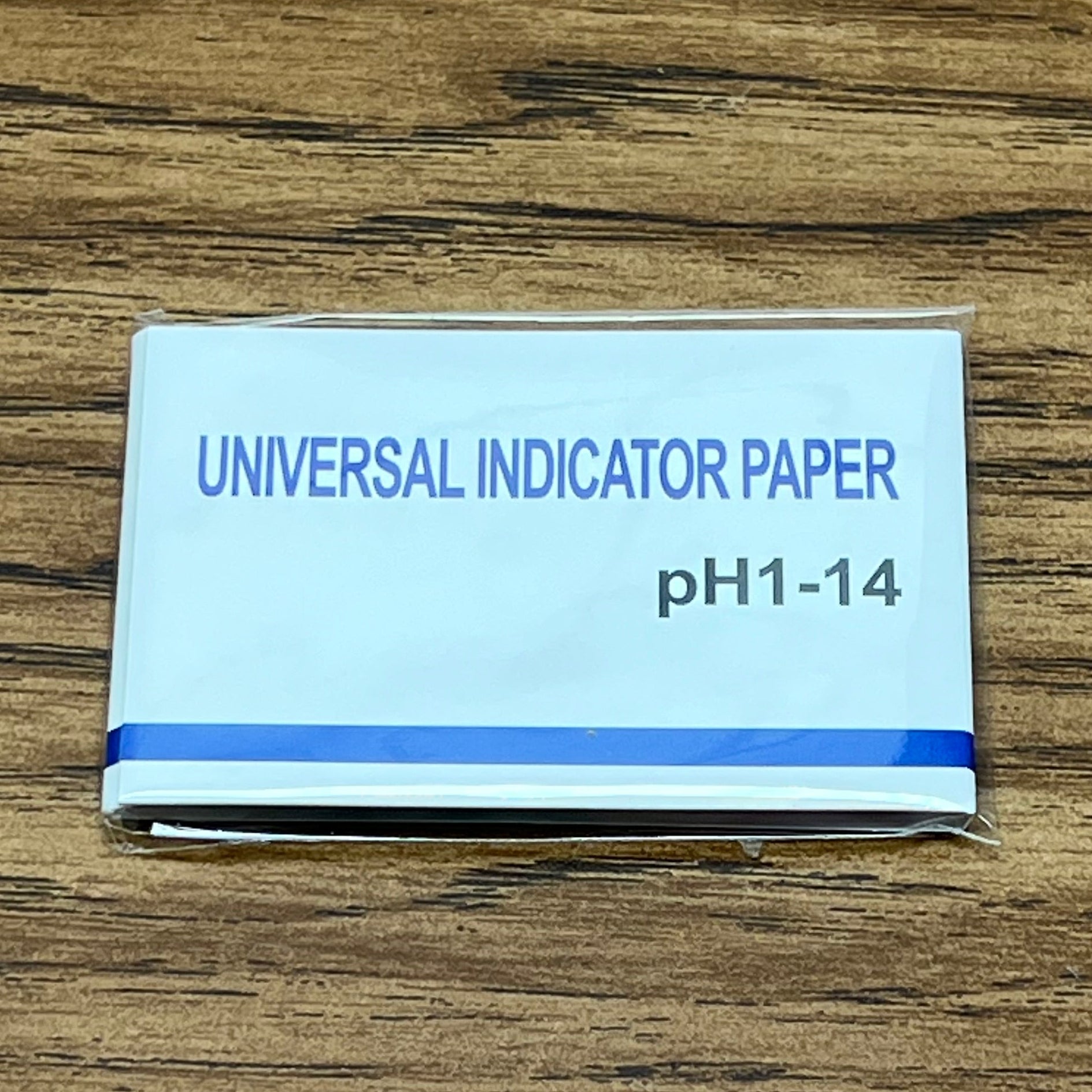 PH test strip pack on woodgrain table top
