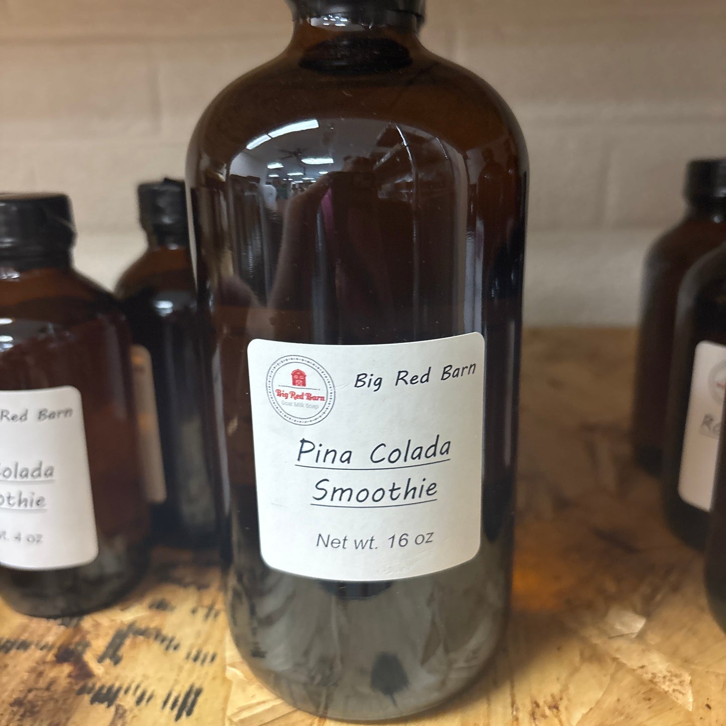 Bottle of Pina Colada Smoothie fragrance with a label on a wooden surface