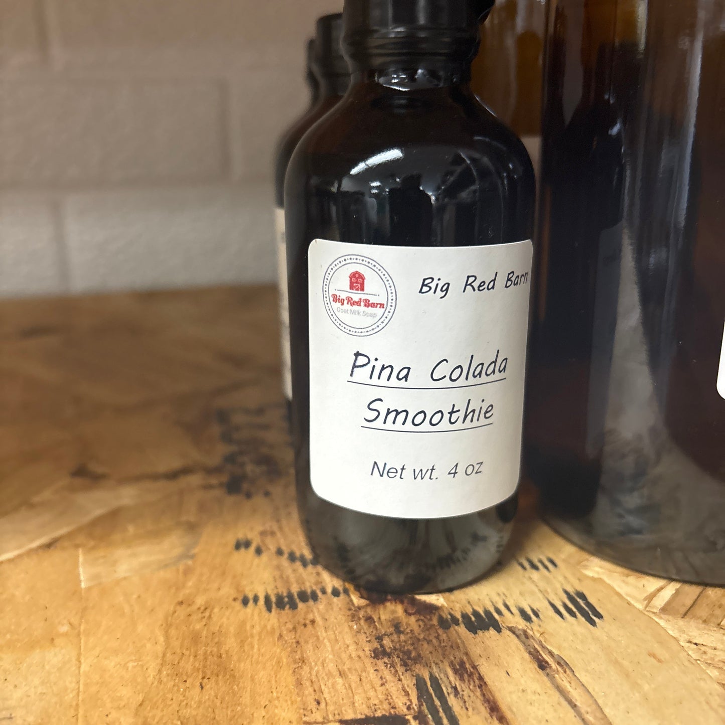 Bottle of Pina Colada Smoothie fragrance on a wooden surface