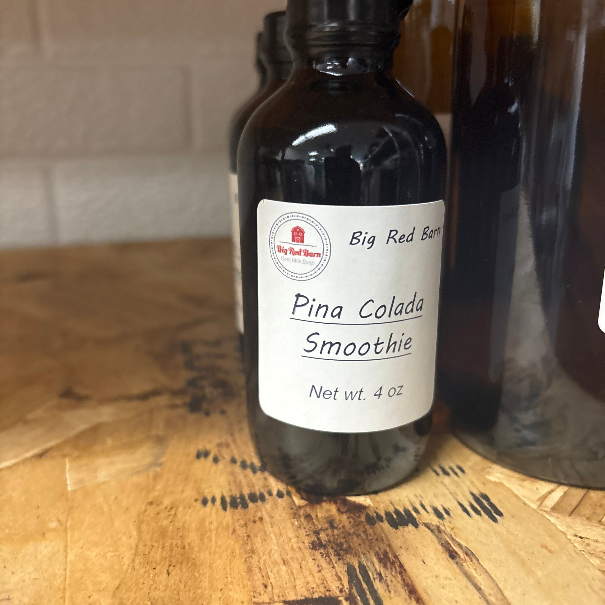 Bottle of Pina Colada Smoothie fragrance on a wooden surface