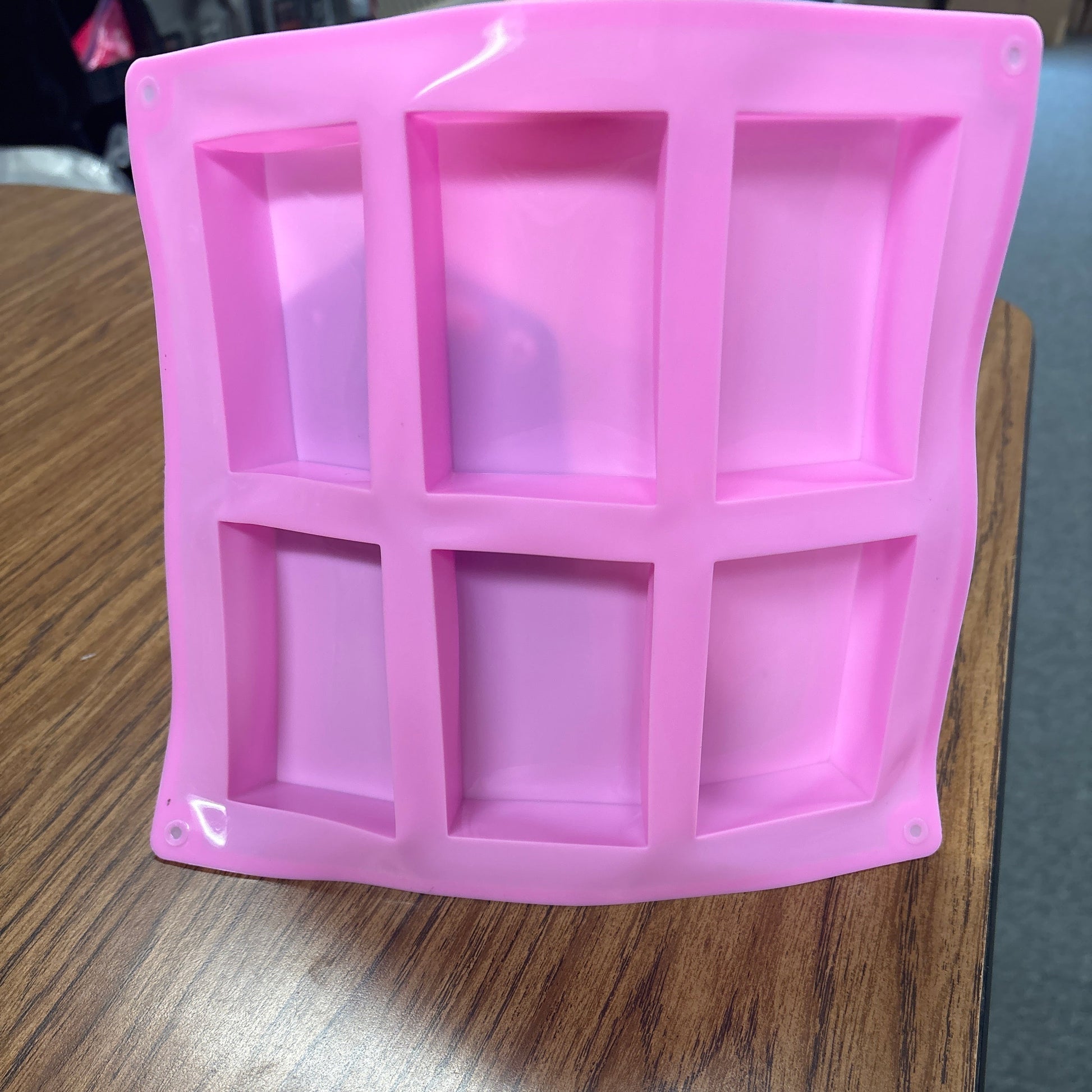 Pink silicone soap mold on a wooden surface