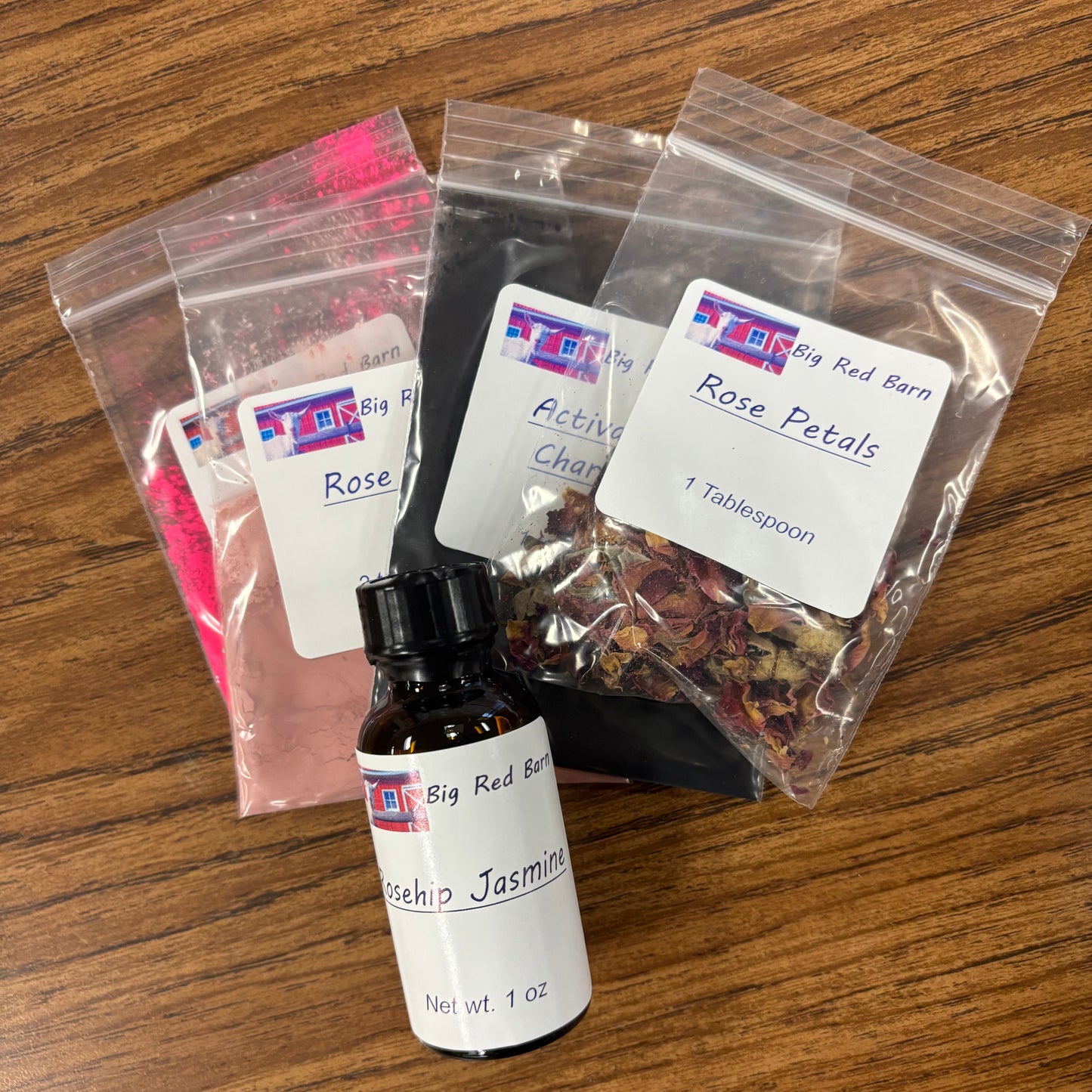 3 colorants, petals, and a fragrance bottle sitting on a table