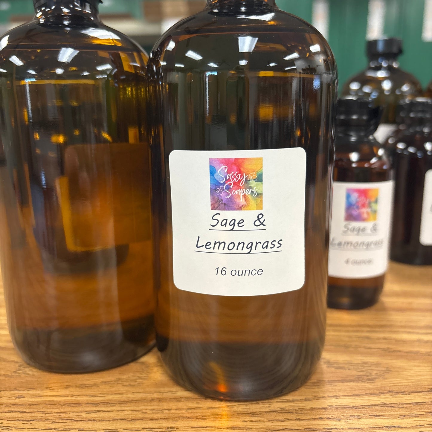Bottle of Sage & Lemongrass Fragrence oil with a colorful label on a wooden surface.