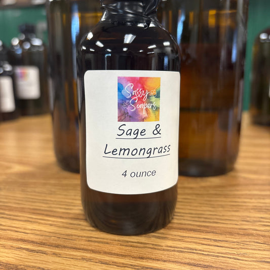 Bottle of Sage & Lemongrass fragrance oil with a colorful label on a wooden surface.