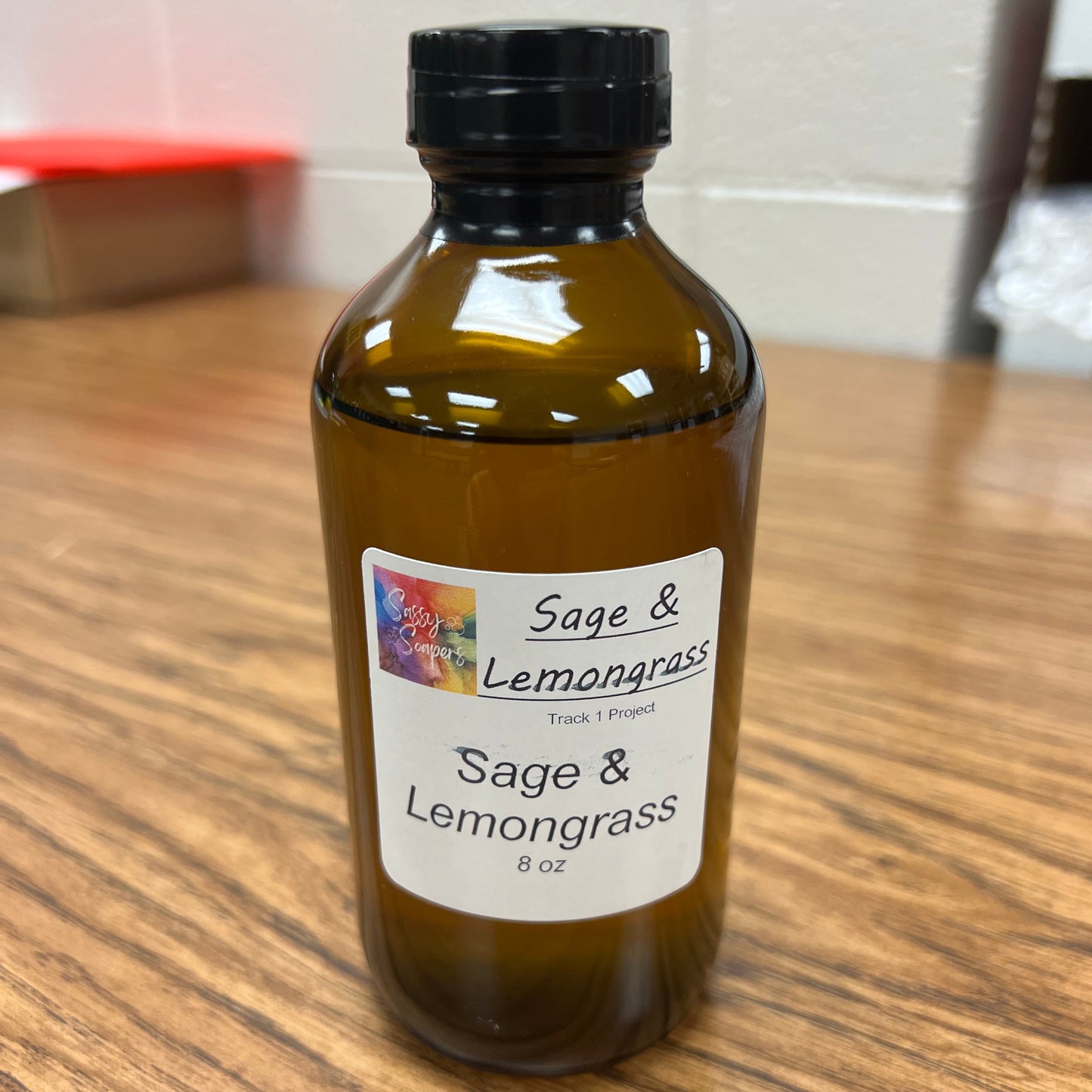 Bottle of Sage & Lemongrass fragrance on a wooden surface