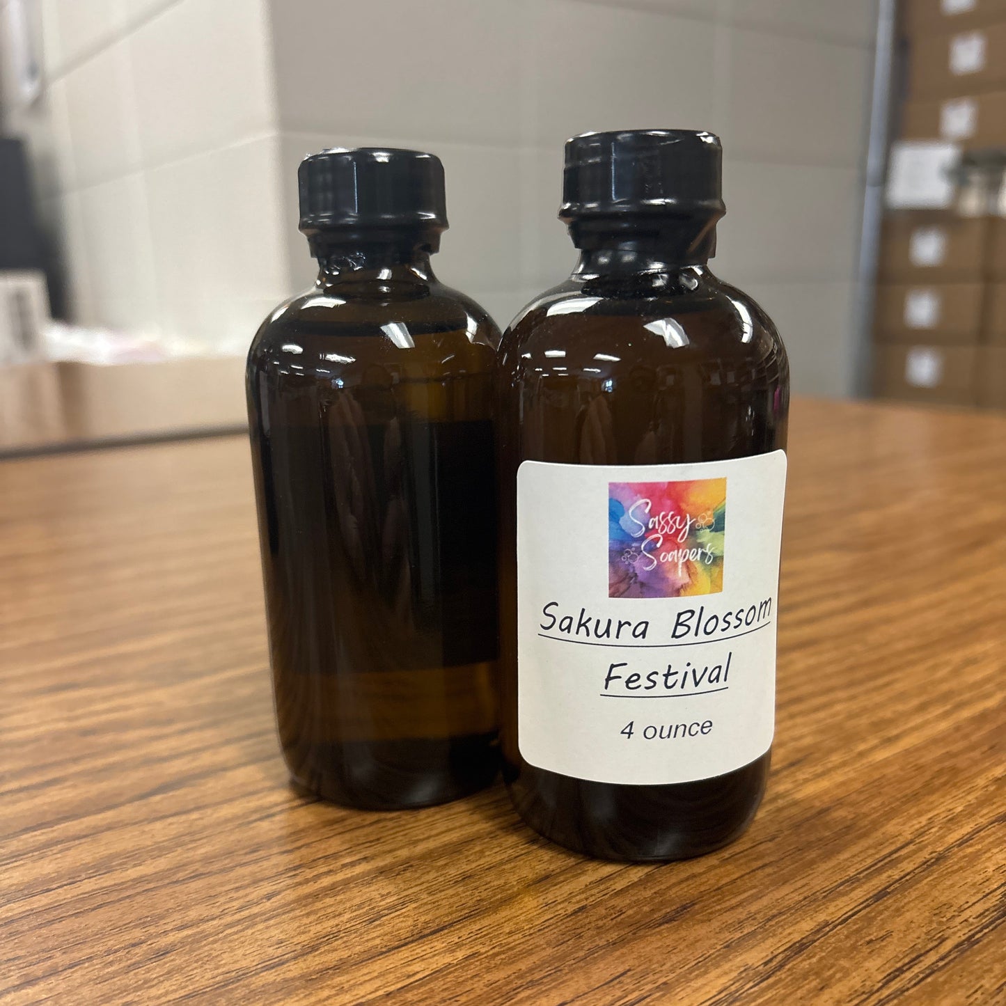 Brown bottle with a label Sakura Blossom festival fragrence on a wooden surface