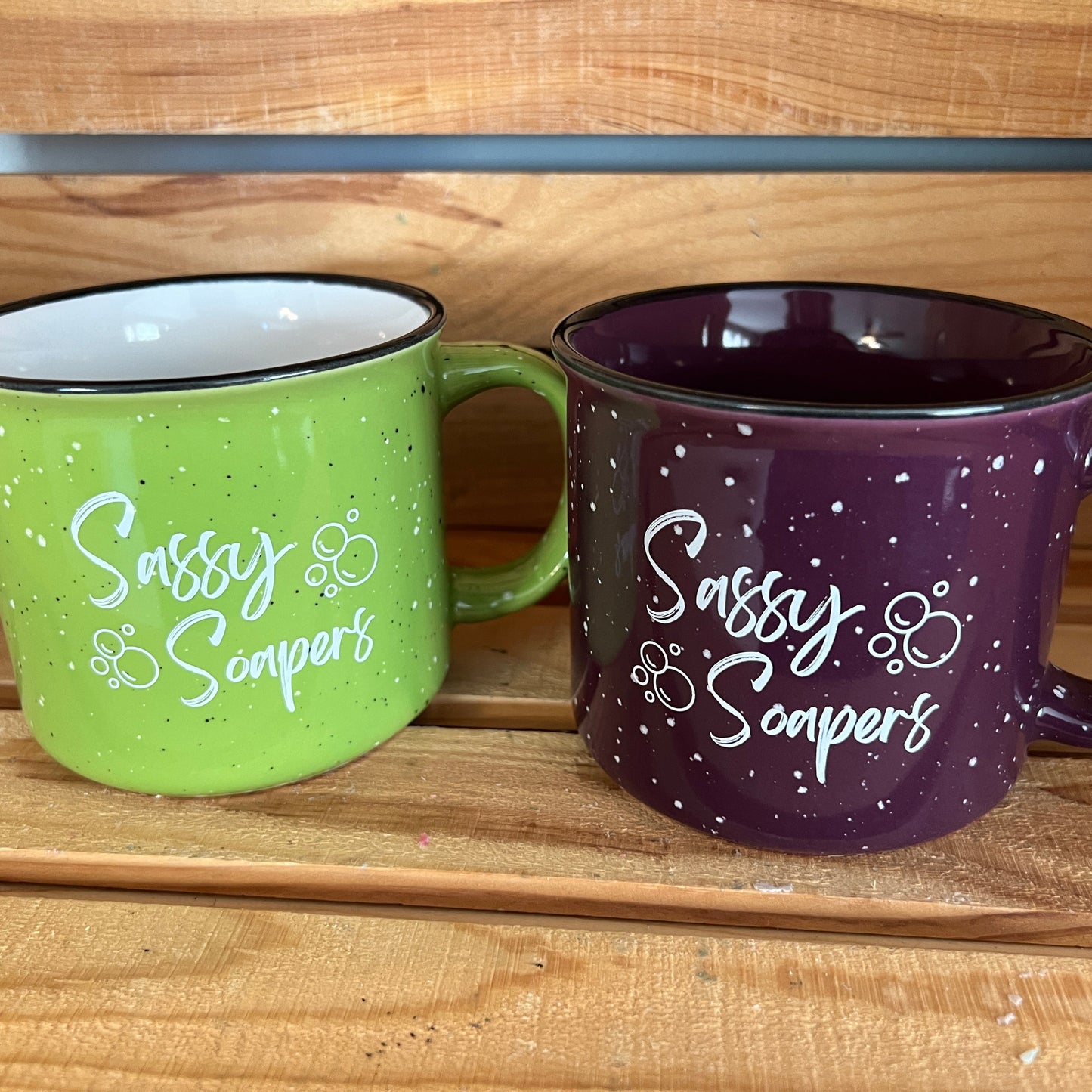 2 Mugs sitting on a wooden shelf