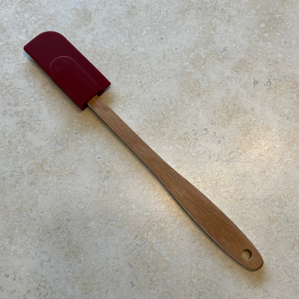 Small red rubber spatula with wooden handle