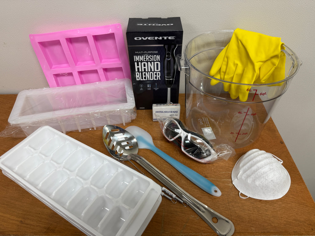 Collection of kitchen items including ice cube trays, a blender, measuring cups, and utensils on a wooden surface.