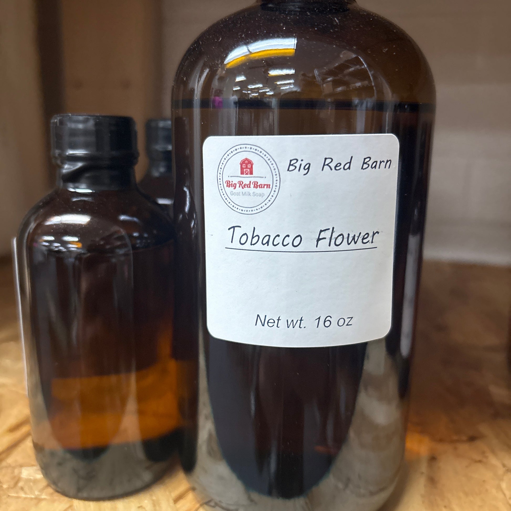 Bottle of Big Red Barn Tobacco Flower fragrence oils with a label on a wooden surface
